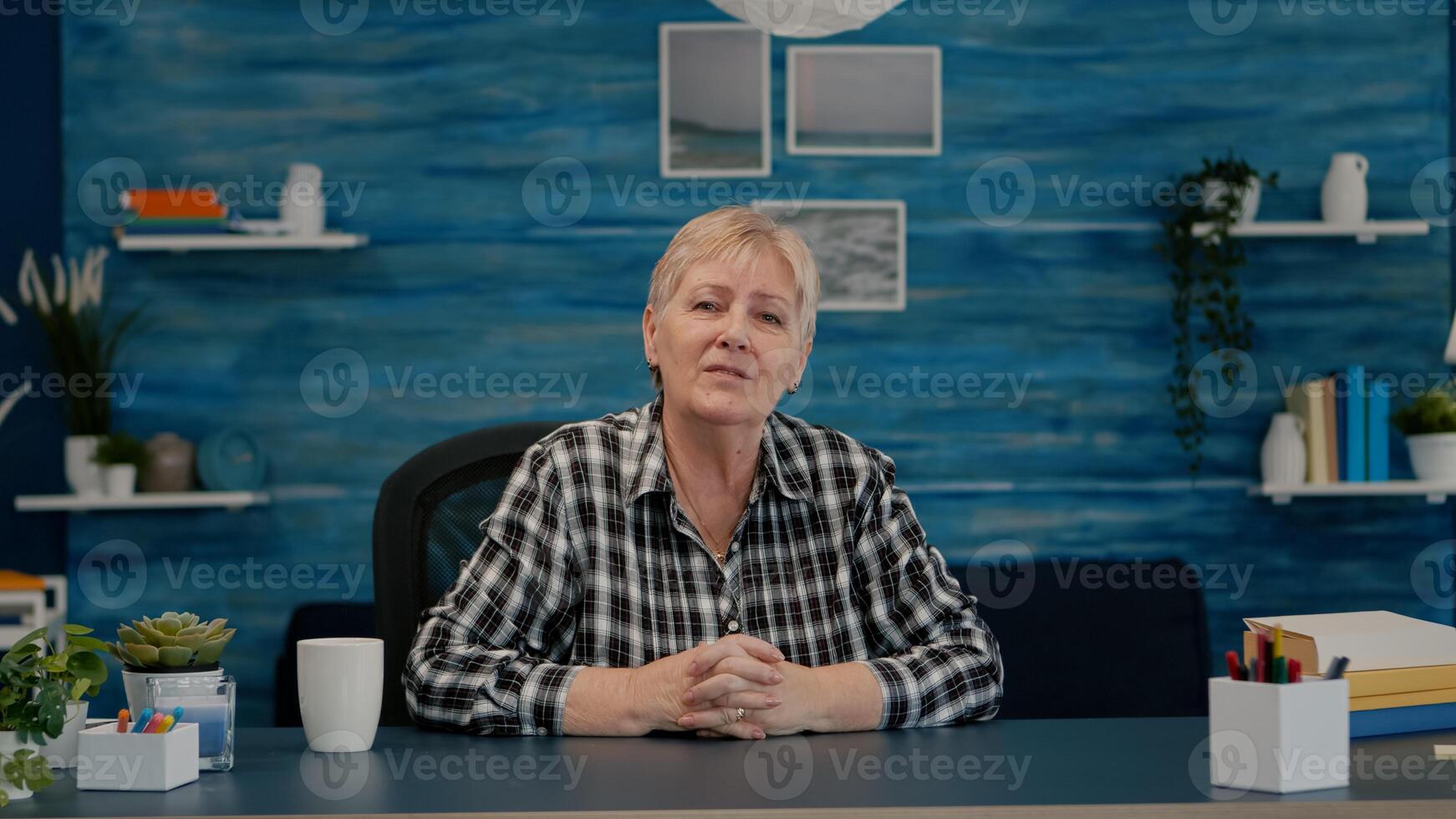 POV of elderly aged woman waving during a conference with business partners working from home. Senior person using internet online chat technology webcam making virtual meeting call connection photo