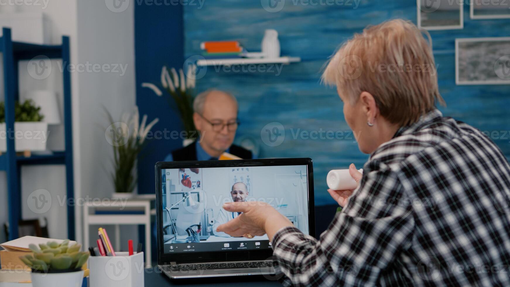 Retired woman talking at telehealth session by internet with young doctor, virtual consulting, telemedicine, remote medic explaning treatment using webcam. Senior lady listening medical online advice photo