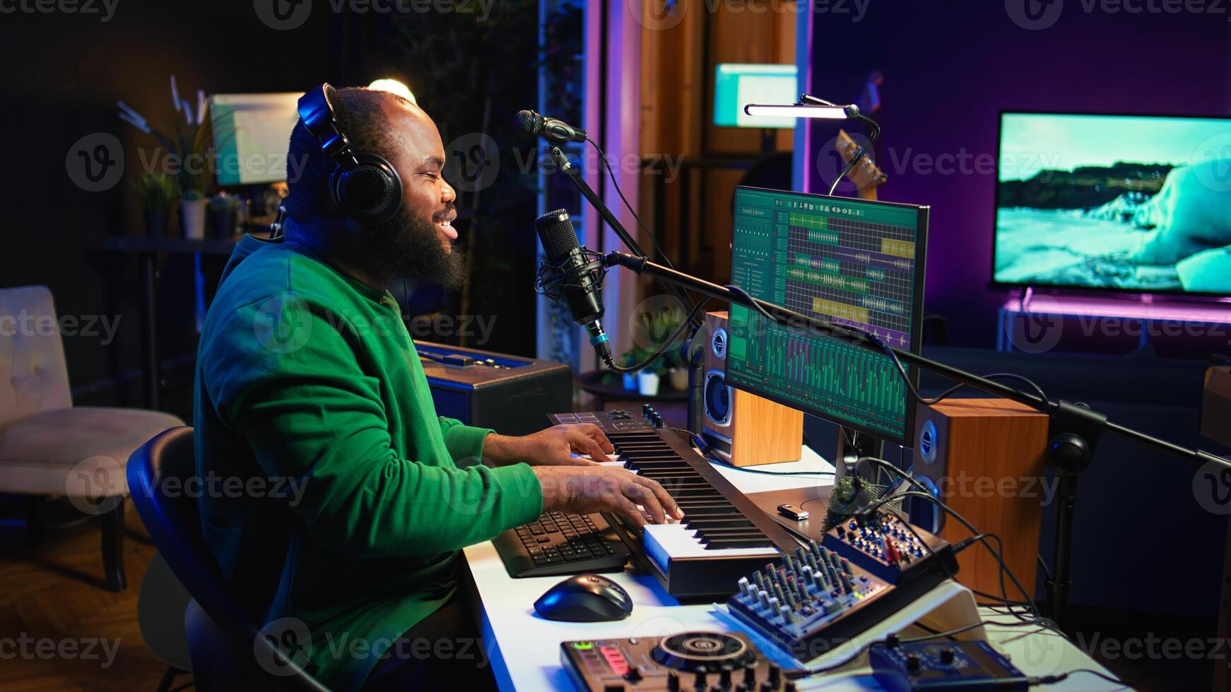 Young artist playing piano keys and singing song on microphone, composing his new music and mixing the tracks on digital interface. Producer technician composing melody with gear. Camera B. photo