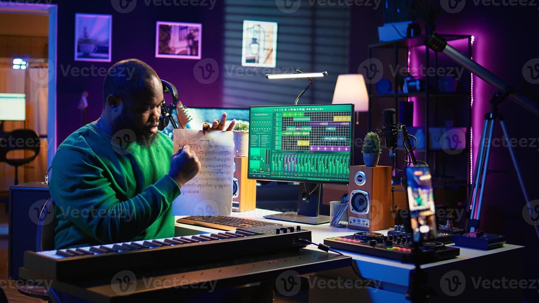 Talented composer explaining musical sheet notes during online master class recorded with smartphone in home studio. Artist musician teaching people how to read and sing accords on piano. Camera B. photo