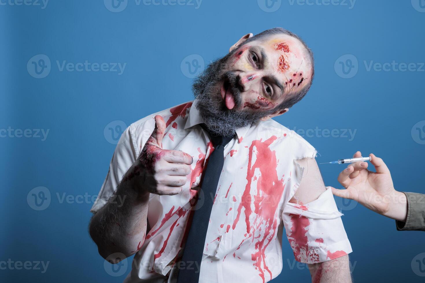 Man covered in blood and bruises receiving rabies vaccine after being attacked by feral animals, showing thumbs up sign during recovery. Wounded person getting antivenom shot, studio background photo