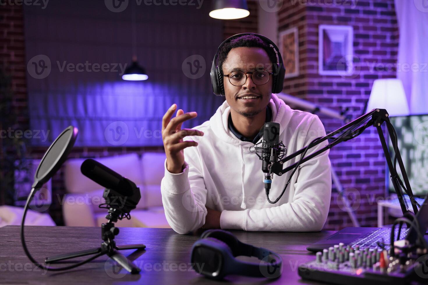 African american vlogger recording online show on camera, using sound equipment in studio. Portrait of content creator talking to audience looking at camera and filming social media channel vlog photo