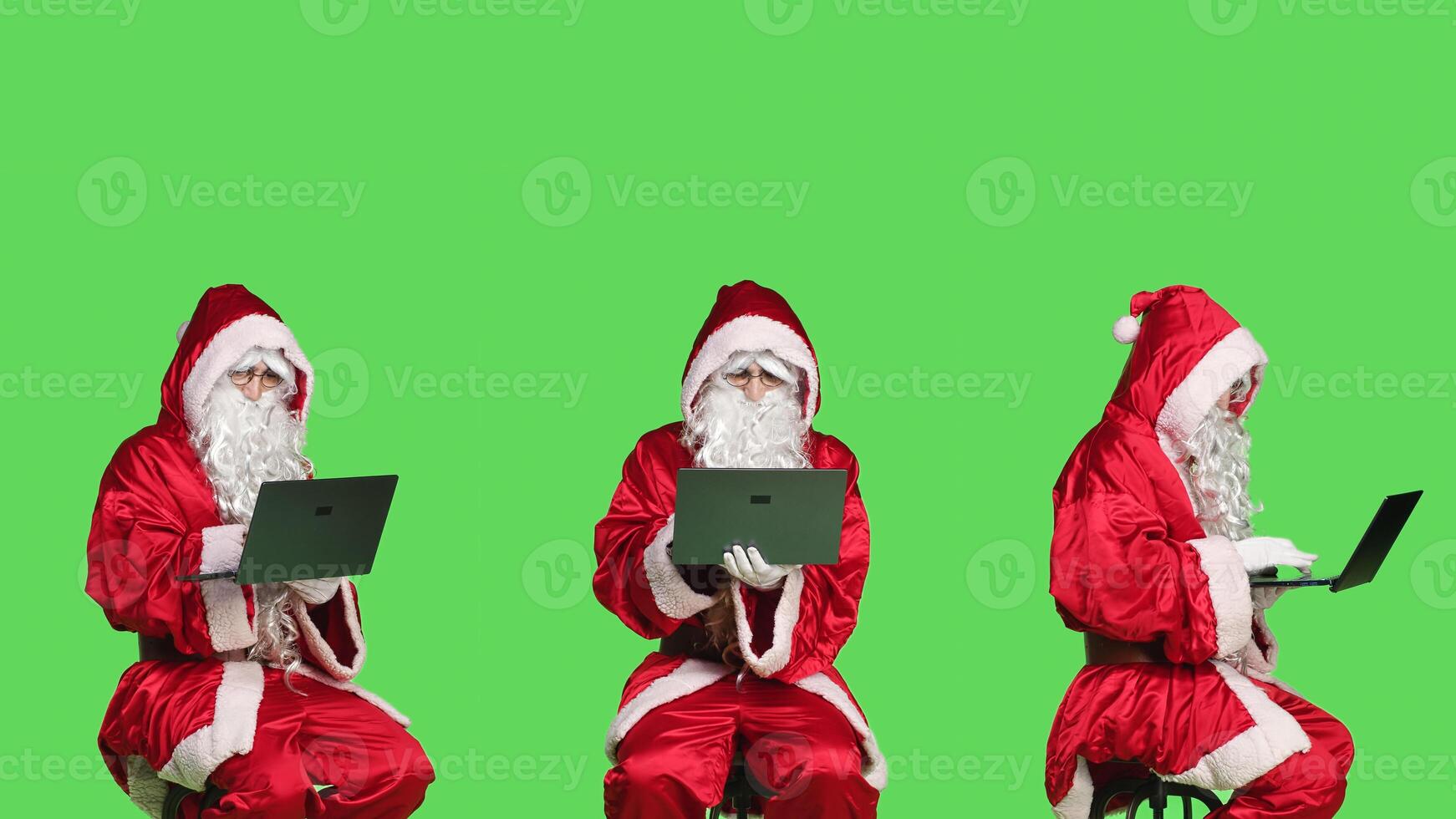 Young man as santa claus using laptop, posing dressed in red and white festive suit during christmas holiday season. Saint nick sitting on chair scrolling on website, xmas celebration. photo