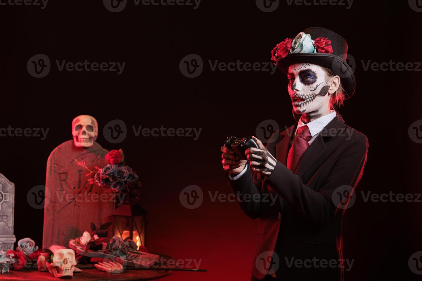 Woman playing videogames with controller in graveyard, celebrating Day of the Dead. Mysterious lady gaming with gamepad, surrounded by frightening funeral items during Halloween horror event photo