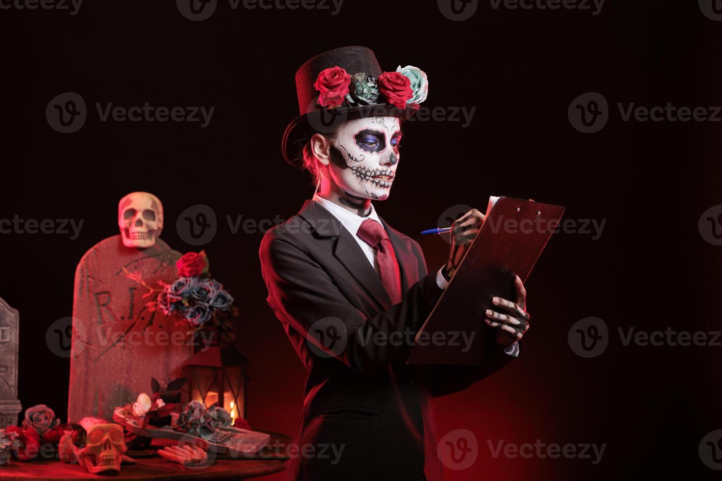 Dark lady looking over paperwork files during Dia de los Muertos, preserving cultural traditions. Woman holding clipboard, checking documents, wearing la Catrina costume to celebrate Mexican culture photo