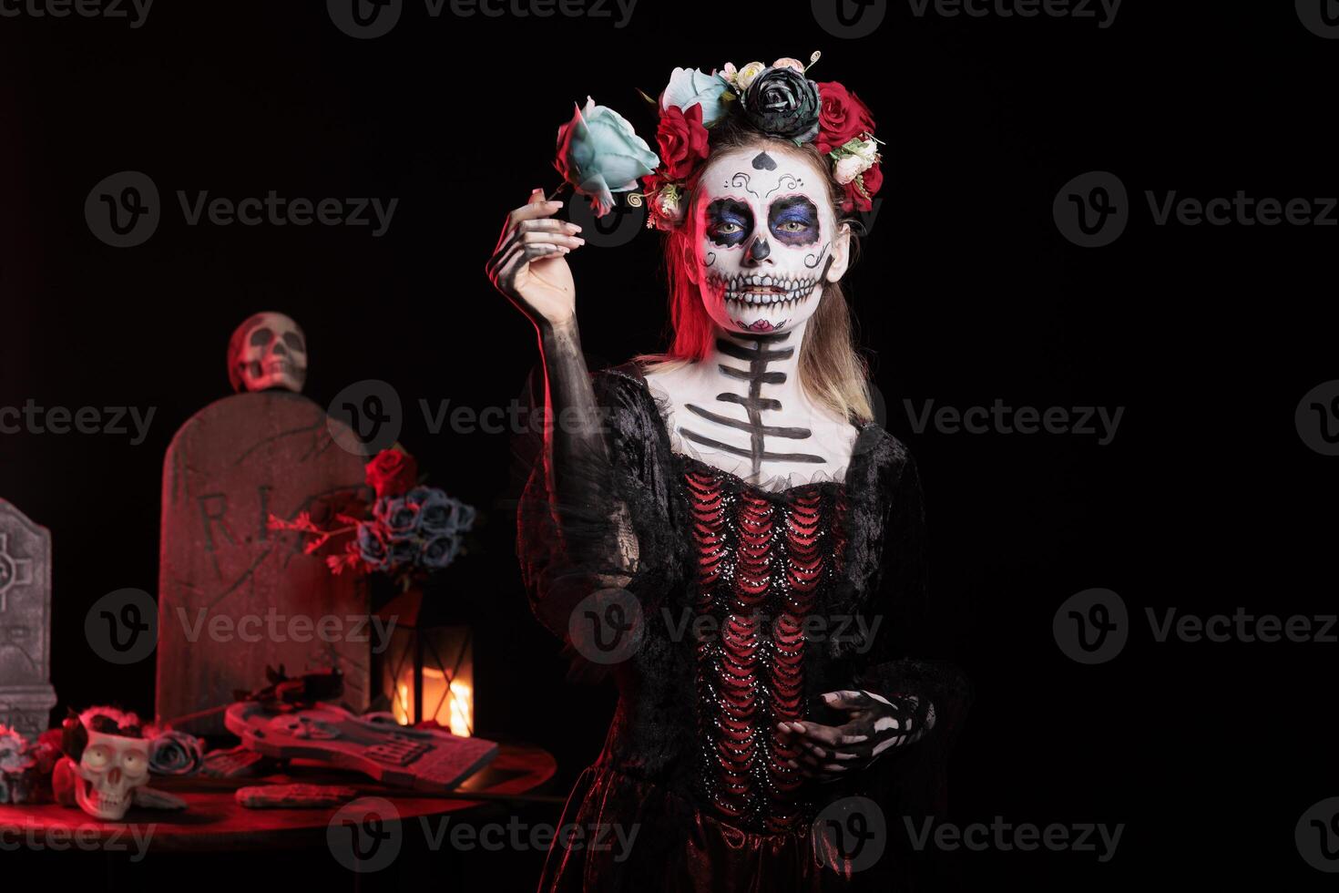 Sinister person posing with blue rose during Dia de los Muertos, preserving cultural traditions between generations. Lady wearing elegant la Catrina dress to celebrate Mexican culture photo