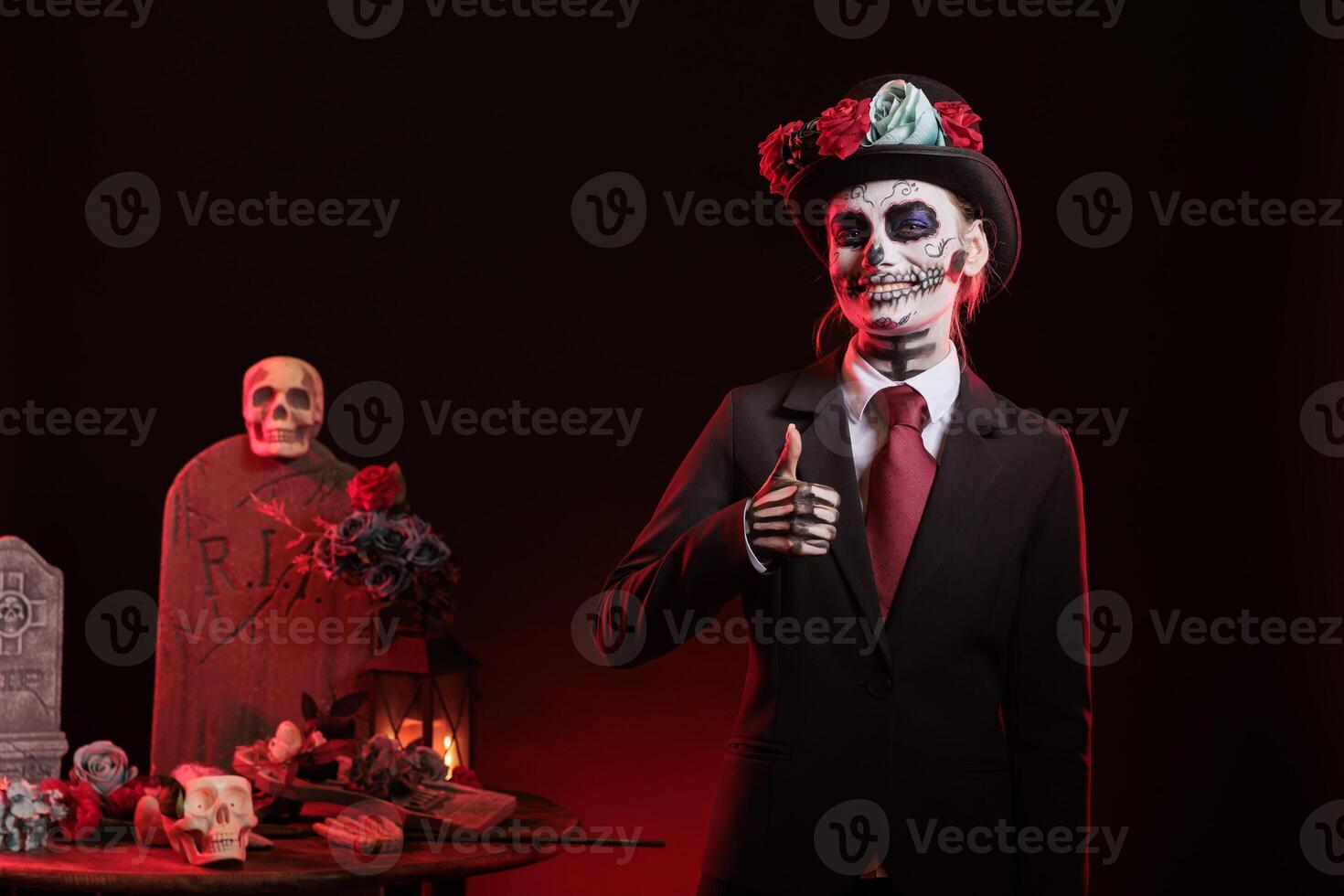 Portrait of jolly woman doing thumbs up gesture during Day of the Dead event honoring dead loved ones. Satisfied lady doing approval gesturing during ancient Aztec custom of celebrating ancestors photo
