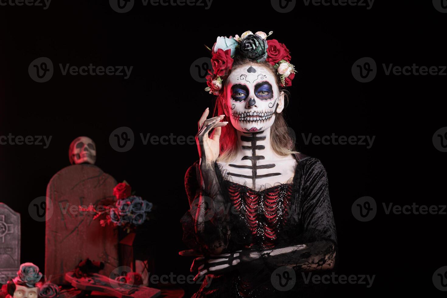 Woman at Day of the Dead event to remember the deceased, celebrating their memory, grave site background. Lady wearing skull face paint for mexican holiday of remembrance for those who have passed photo