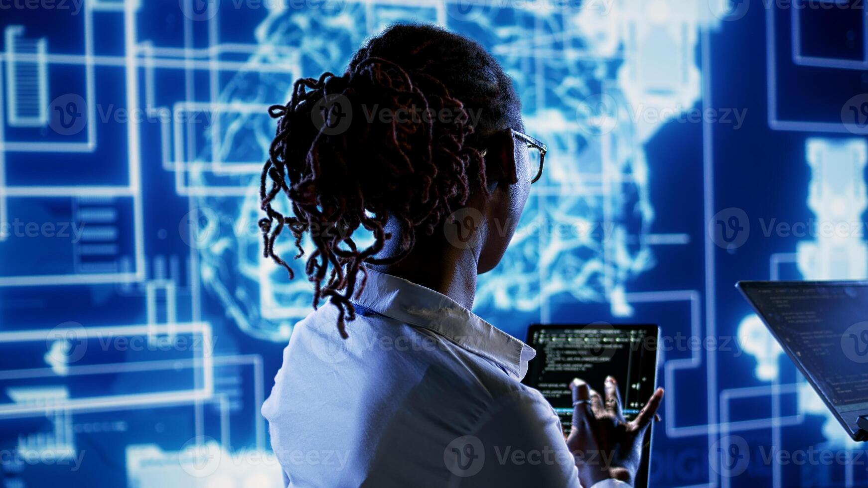 Engineering coworkers updating AI systems, writing intricate binary code scripts on tablet and laptop. Trained technicians using programming to upgrade artificial intelligence simulation model photo