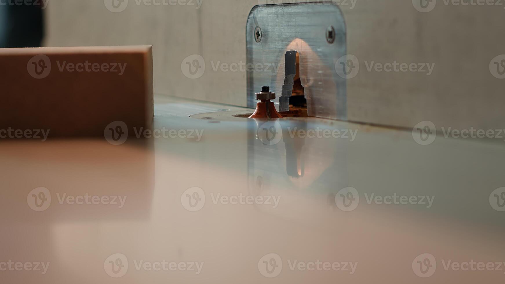 Man putting lumber block through spindle moulder, creating smooth edges on wooden piece. Joiner using heavy machinery to craft joints for furniture and structures, camera A close up photo