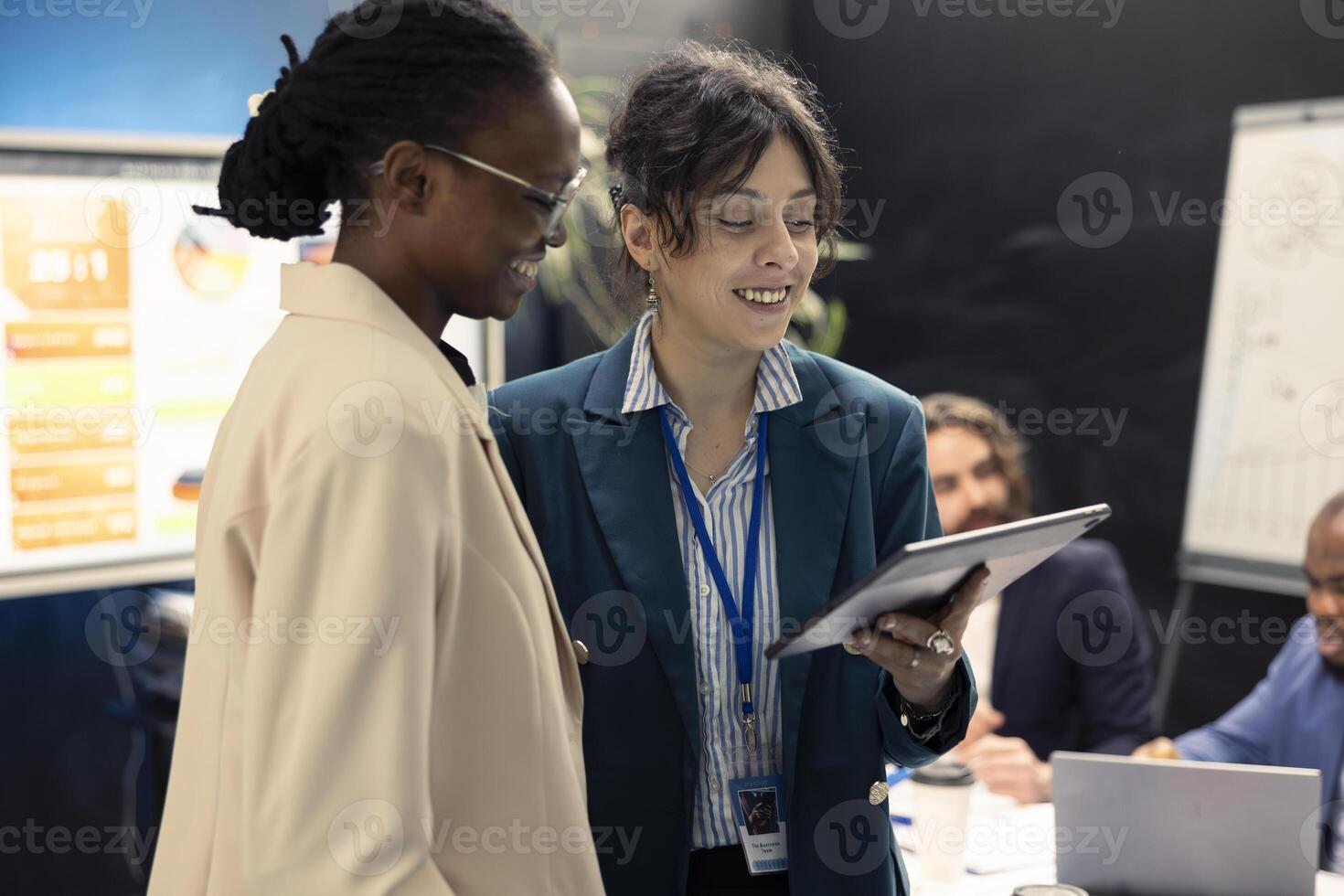 Team of women joining forces to make a great briefing presentation for their coworkers, showing insight on project updates or details. Employees gathered in a meeting room to explore opportunities. photo