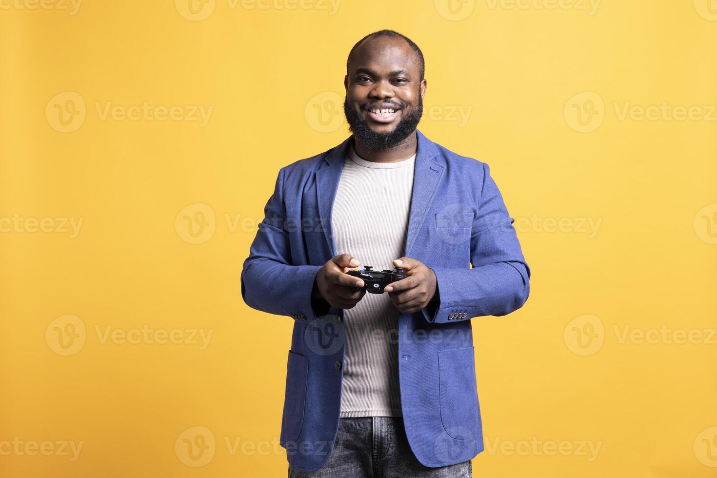 Portrait of cheerful man playing videogames holding controller, isolated over studio background. Gamer smiling, having fun by participating in PvP online multiplayer game using console system photo