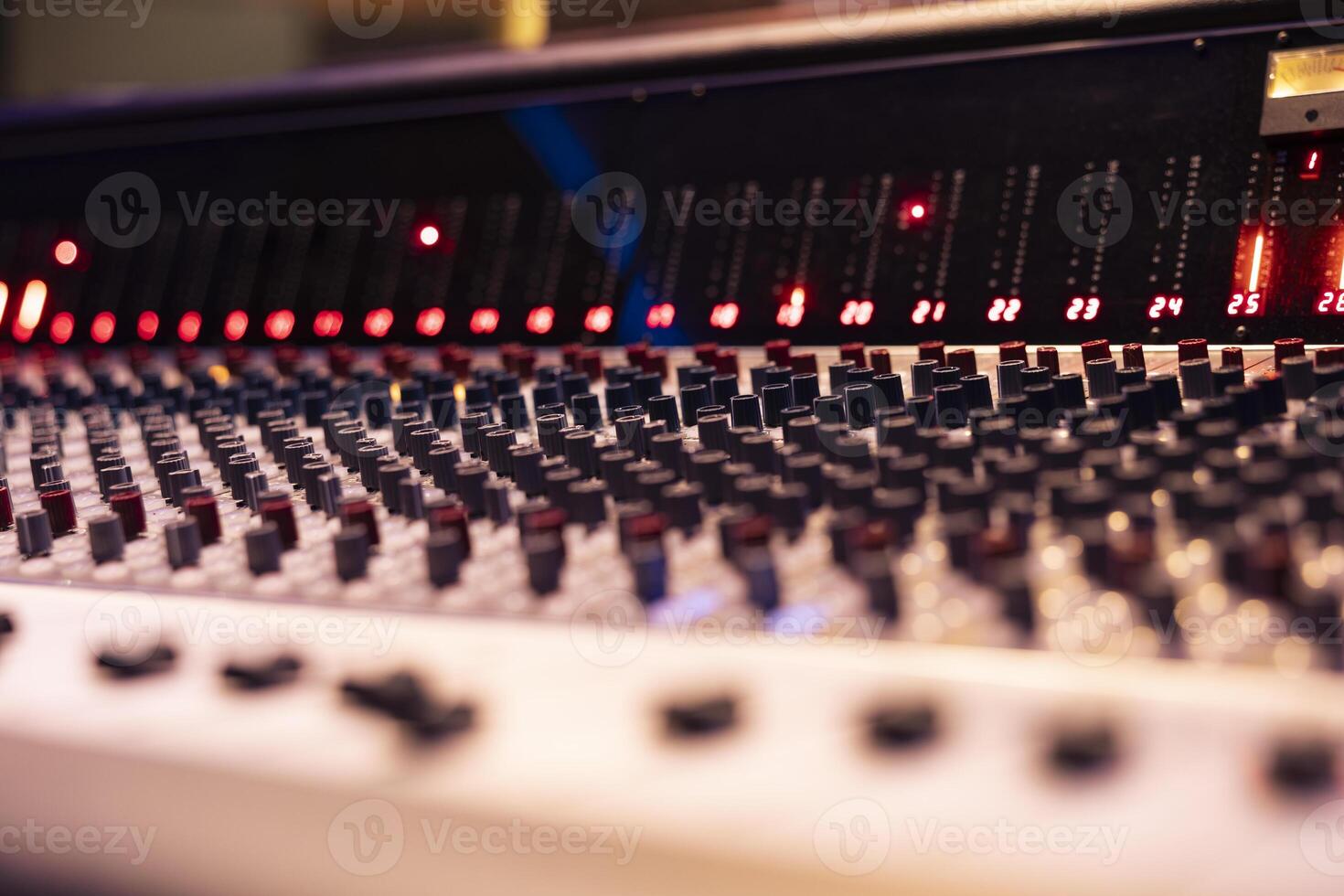 Mixing console and music production knobs in empty control room, technical gear used for recording and producing new tracks. Switchers, sliders and buttons editing audio files. Close up. photo