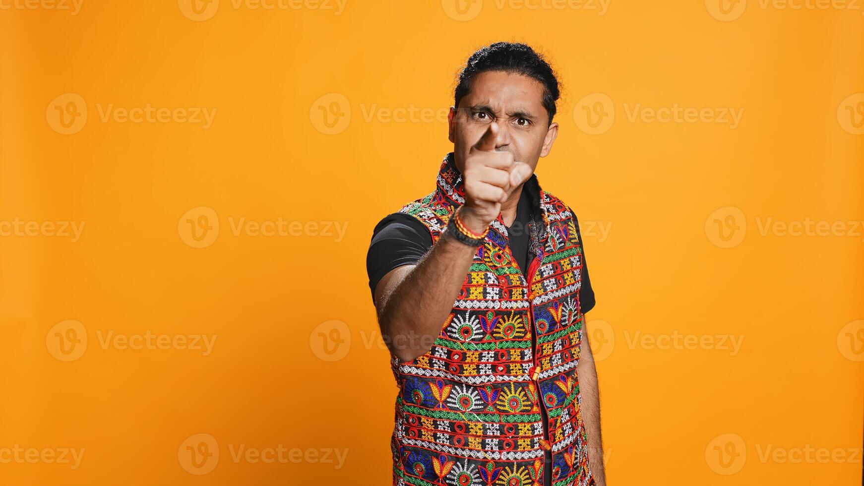 Disappointed indian man admonishing friend over debacle, isolated over studio background. Upset person in disagreement with mate, pointing finger and lecturing him, camera B photo