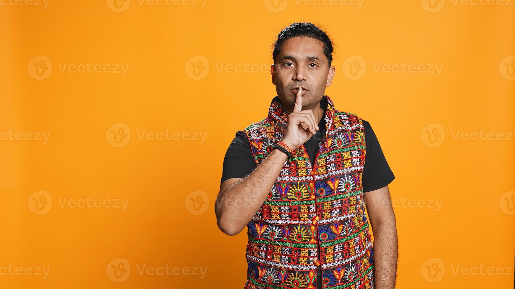 Authoritative man doing shushing hand gesturing, demanding secrecy, irritated by noise. Stern person complaining, placing finger on lips, doing quiet warning sign gesture, studio background, camera B photo