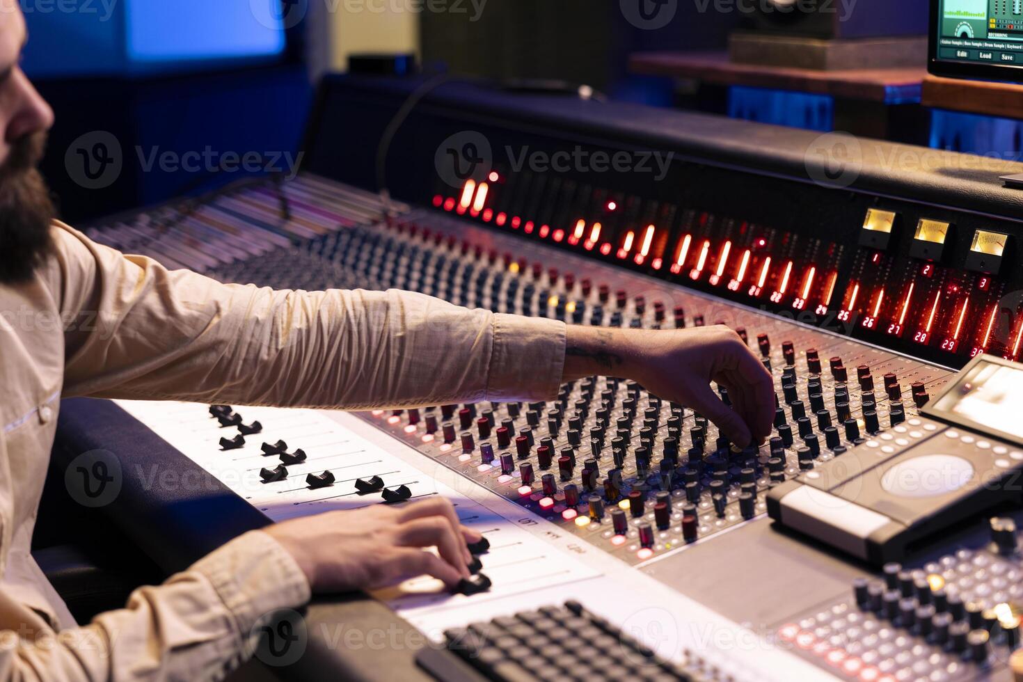 Audio editor changes and blends records to create fresh tracks, adding sound effects to boost audio recordings quality. Music production expert working in professional studio control room. photo