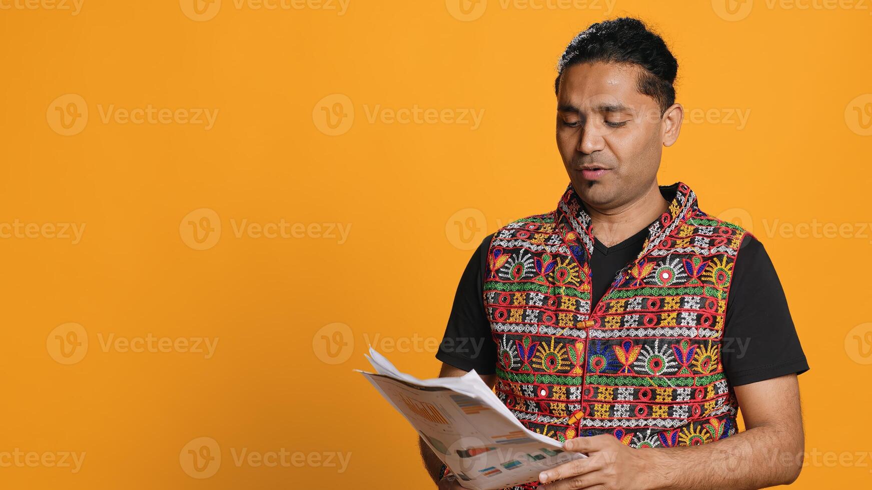 Indian man browsing though financial audit report files, throwing them in anger, feeling overworked, studio background. Stressed worker annoyed by paperwork, refusing to work anymore, camera A photo