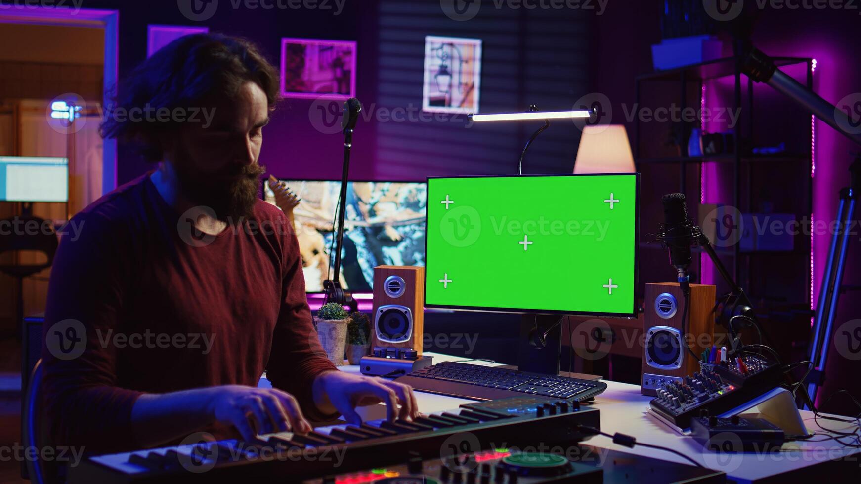 Musician playing piano midi controller and learning new notes, looking at online lesson on pc. Artist uses greenscreen display, learn to play keys on electronic keyboard. Camera B. photo
