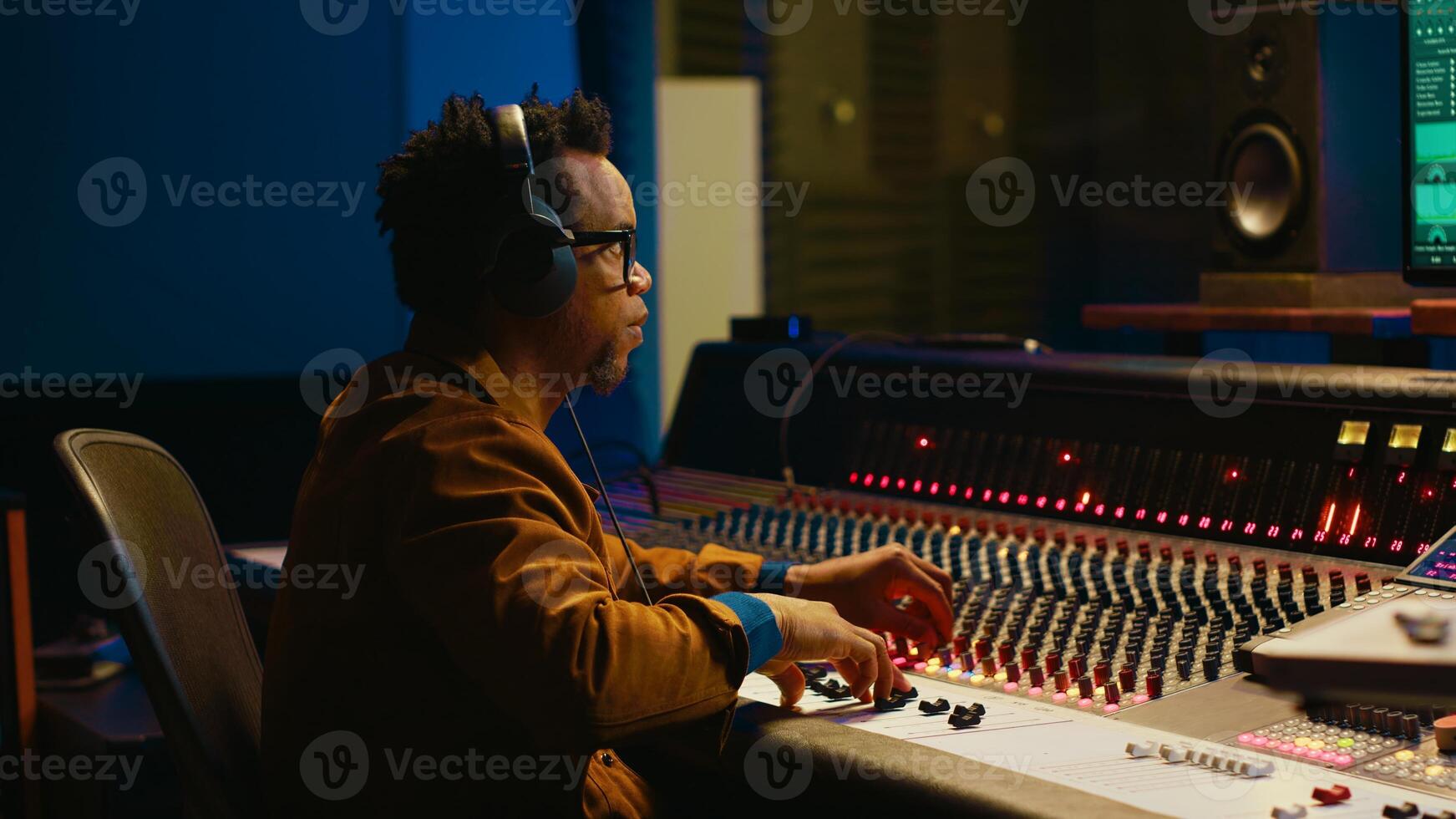 Audio designer leveling sound on a mixer control desk, professional music studio concept. Producer turns up volume and adding effects on a mixing console, recording live tracks. Camera A. photo