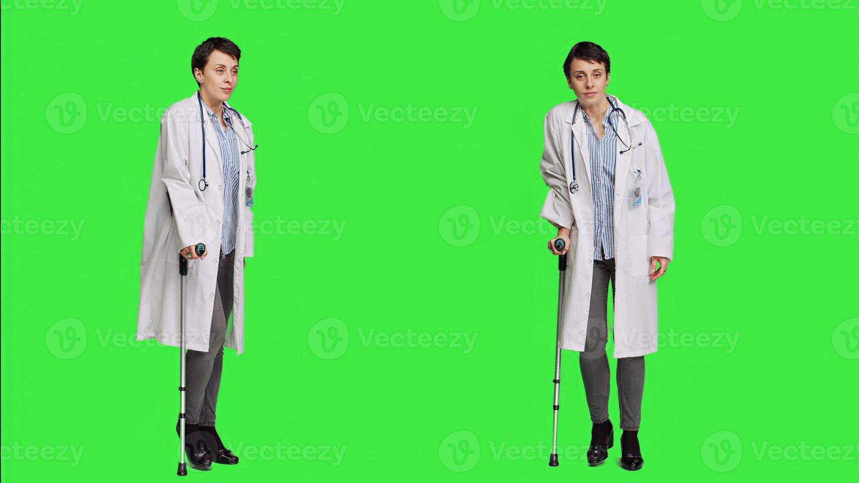 Orthopedics specialist presenting walking tool after fracture or injury, showing crutches to help with recovery. Physician stands against greenscreen backdrop, mobility aid. Camera A. photo