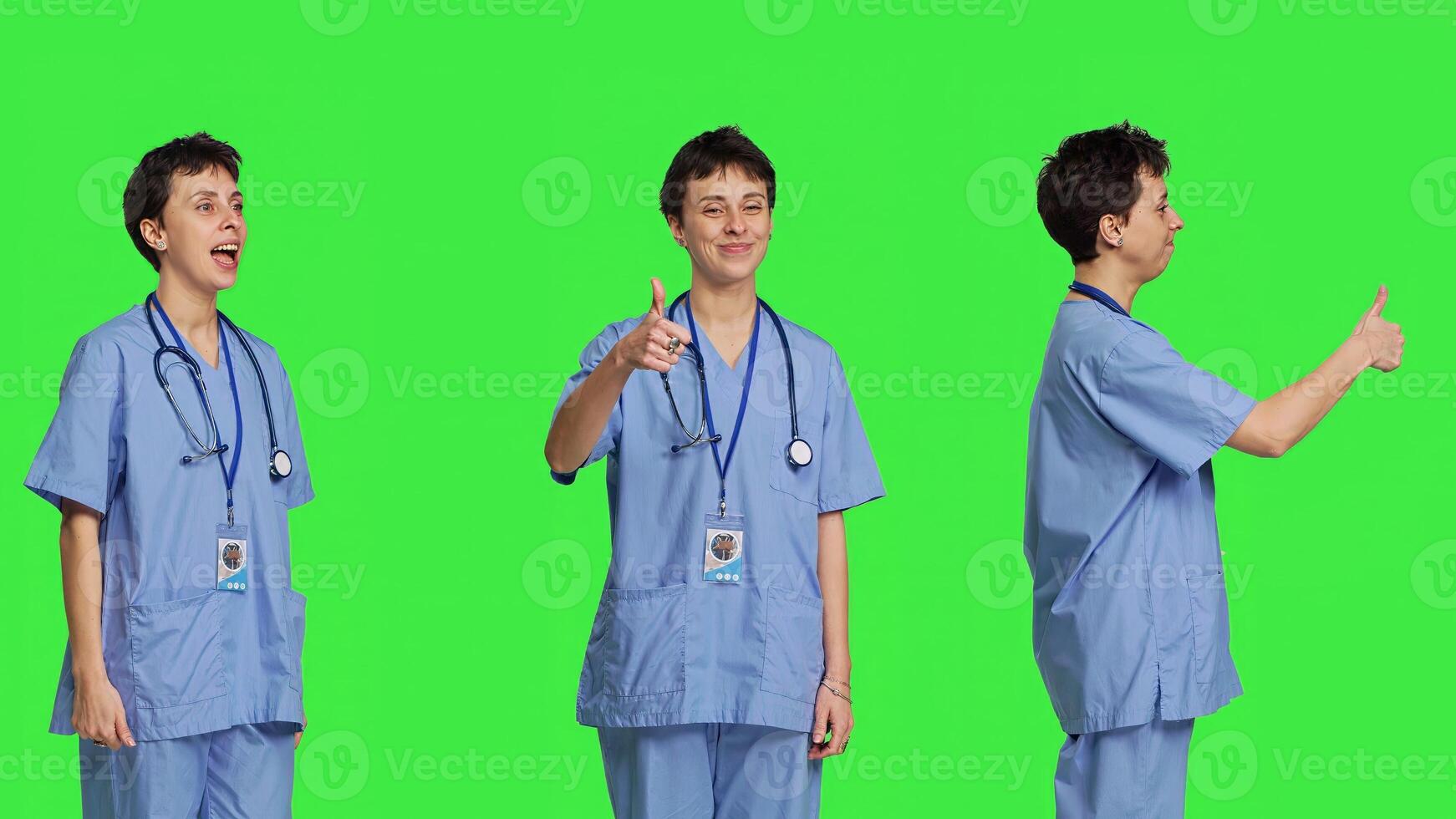 Cheerful nurse giving thumbs up sign against greenscreen backdrop, showing positive gesture with a like. Medical assistant shows her approval, recommending something and being satisfied. Camera B. photo