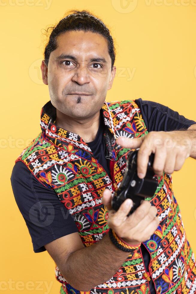 Portrait of person squinting eyes, concentrating on killing foes in videogame with joystick. Devoted gamer pressing gamepad buttons, feeling determined to beat enemies in intensive game, studio backdrop photo
