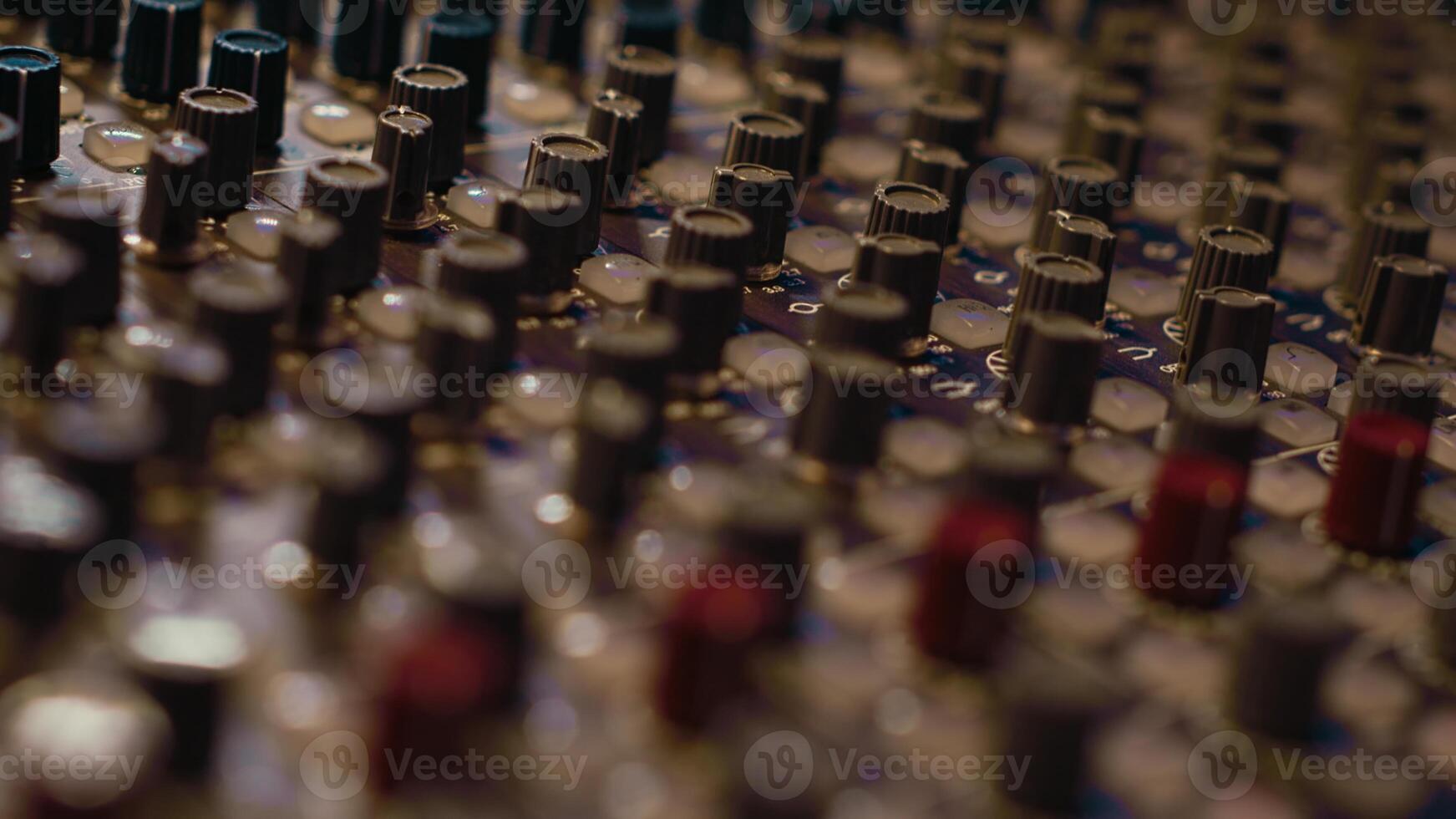 Pre amp knobs and switchers on mixing console panel board, audio stereo equipment used in music post production. Empty control room in professional studio, fader and sliders. Close up. photo