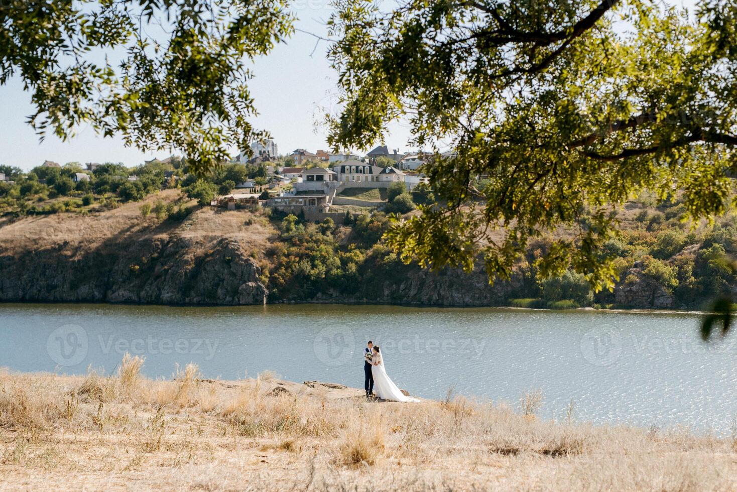 bride blonde girl and groom near the river photo