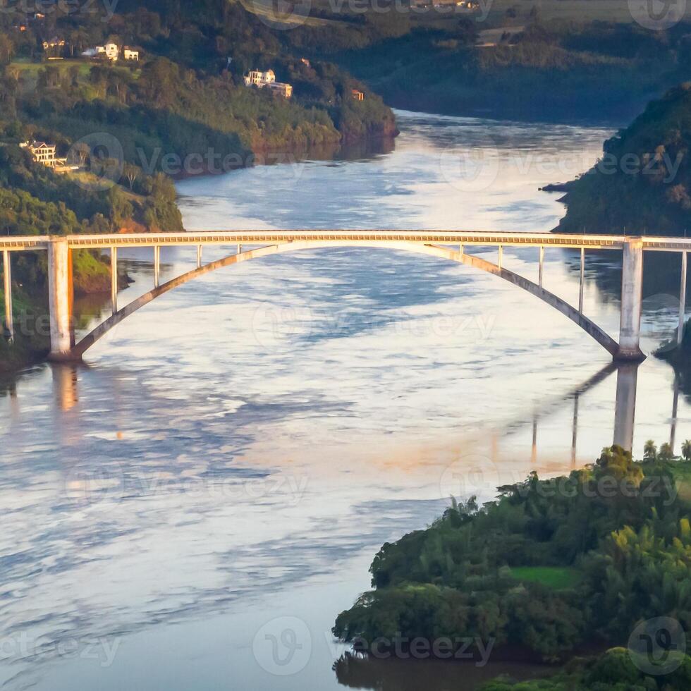 Border between Brazil and Paraguay and connects Foz do Iguacu to Ciudad del Este. Ponte da Amizade in Foz do Iguacu. Aerial view of the Friendship Bridge with Parana river. Square image. photo