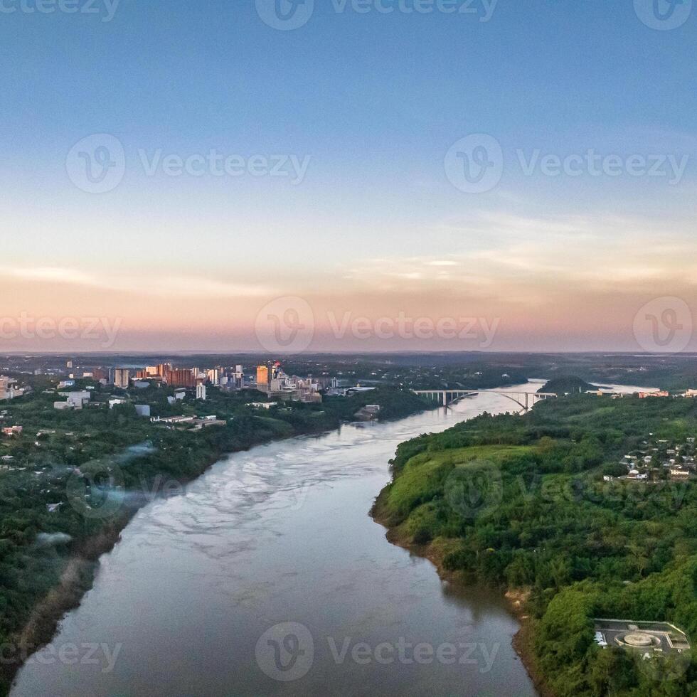 Border between Brazil and Paraguay and connects Foz do Iguacu to Ciudad del Este. Ponte da Amizade in Foz do Iguacu. Aerial view of the Friendship Bridge with Parana river. Square image. photo