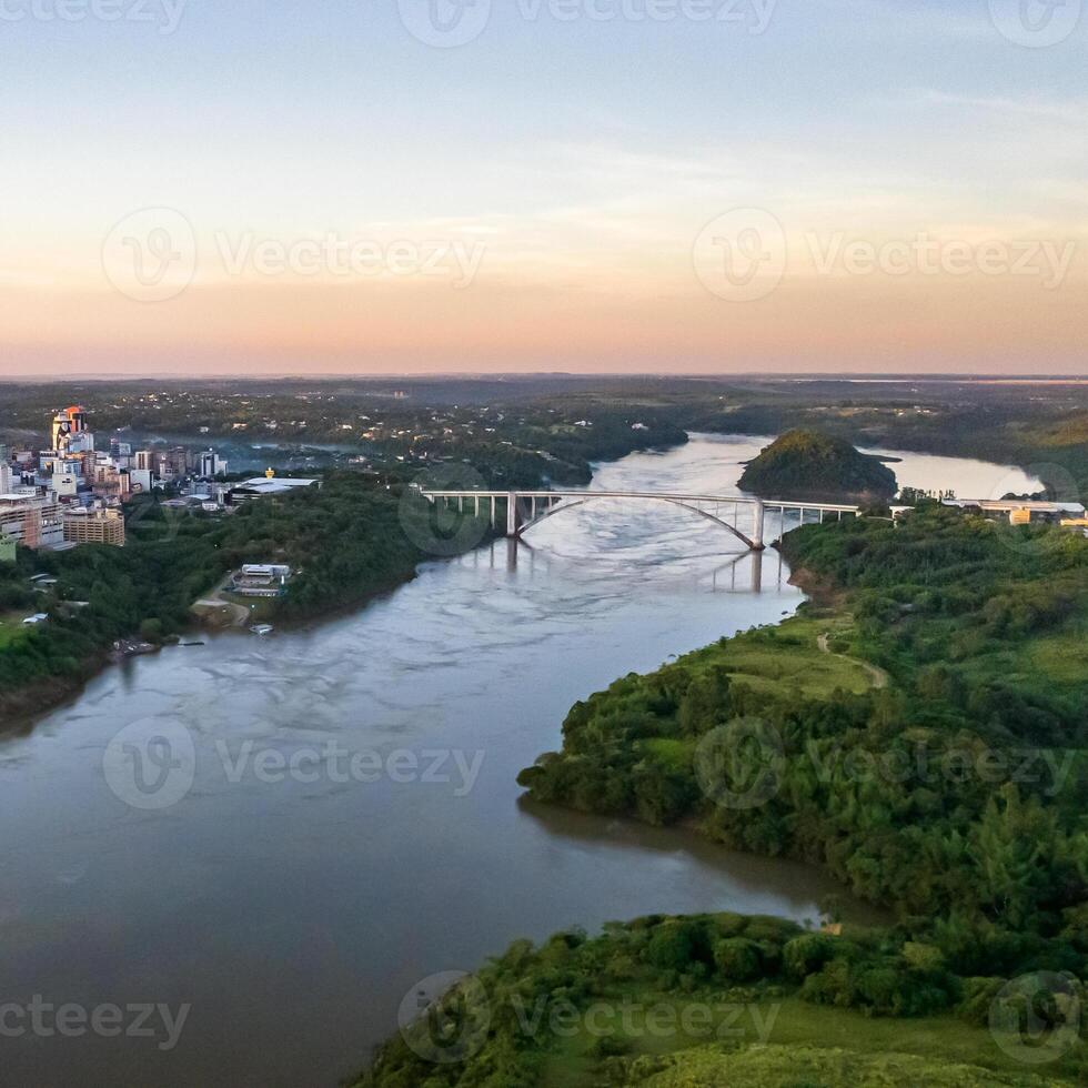 Border between Brazil and Paraguay and connects Foz do Iguacu to Ciudad del Este. Ponte da Amizade in Foz do Iguacu. Aerial view of the Friendship Bridge with Parana river. Square image. photo