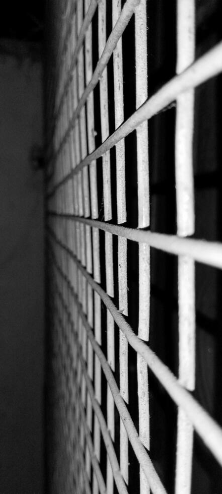 Black and white window photo taken at night by mobile torch light.