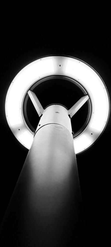 A beautiful black and white photograph of a light bulb illuminated at night. photo