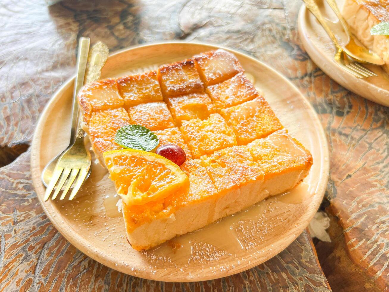 Toast cut into cubes is placed on a wooden plate and decorated with an orange on top. photo