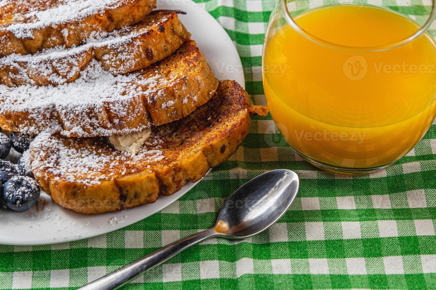 French toast on a white plate with blueberries and orange juice for breakfast photo