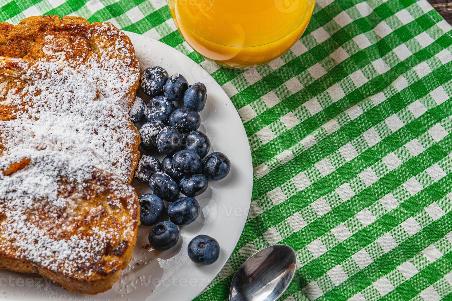 French toast on a white plate with blueberries and orange juice for breakfast photo