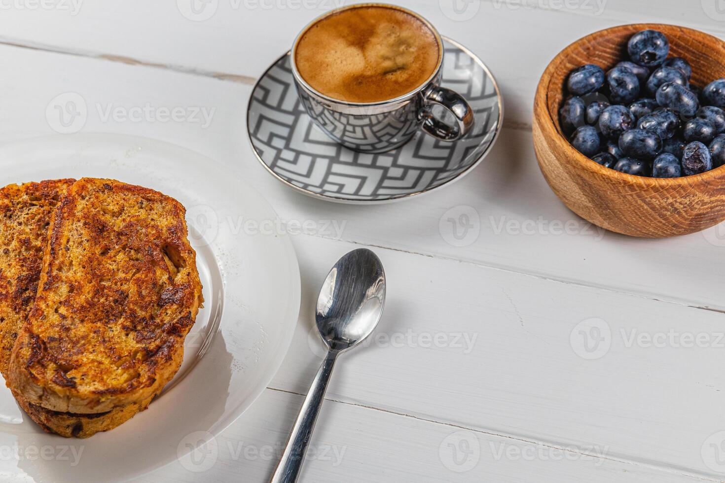 French toast on a white plate with blueberries and coffee for breakfast photo