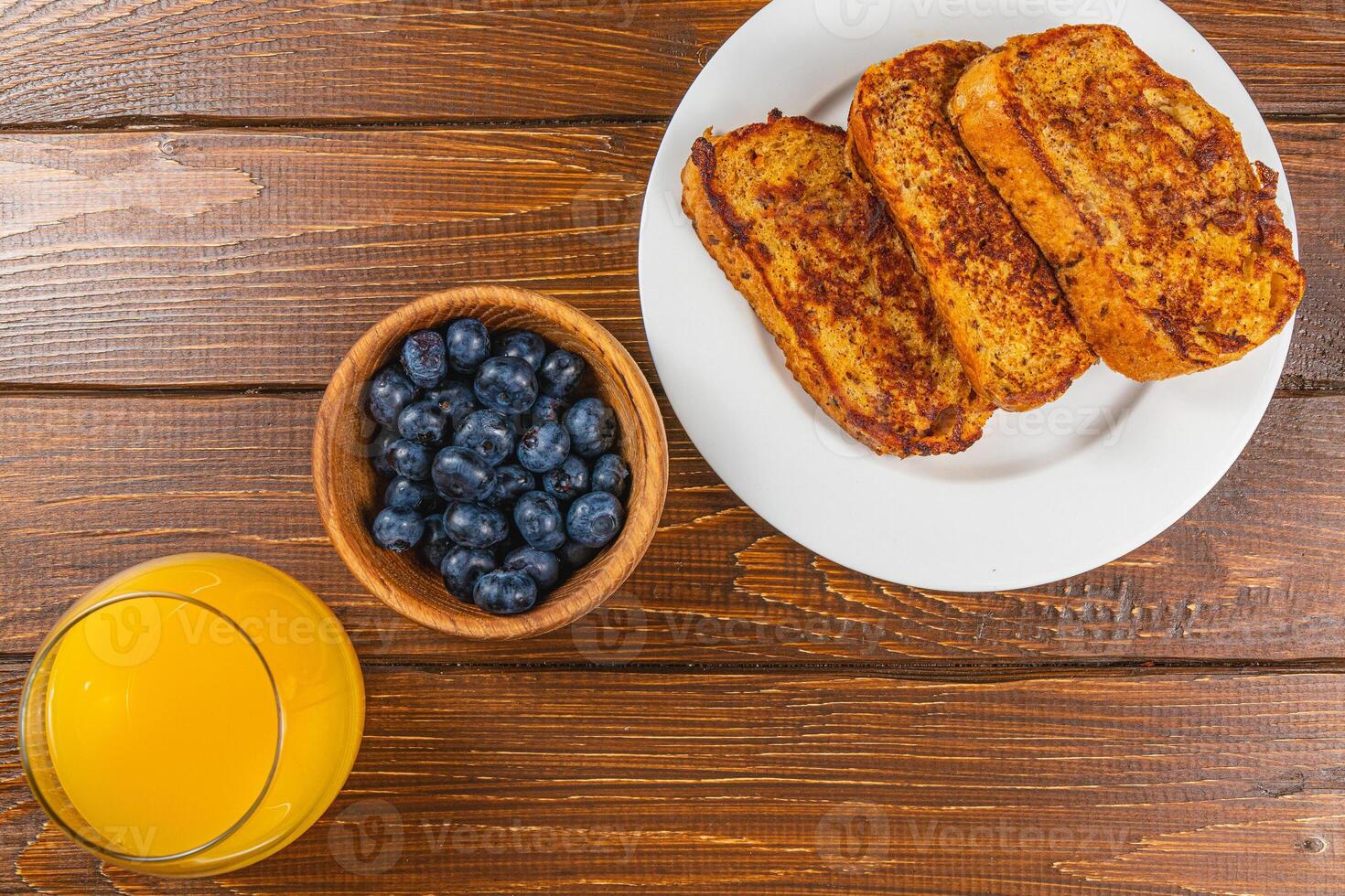 French toast on a white plate with blueberries and orange juice for breakfast photo