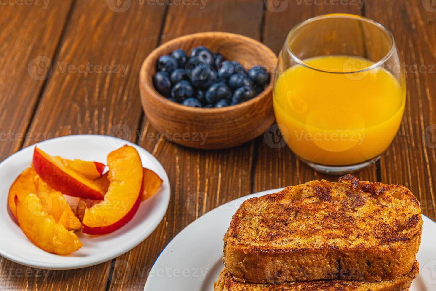 French toast on a plate with blueberries, orange juice, nectarine for breakfast photo