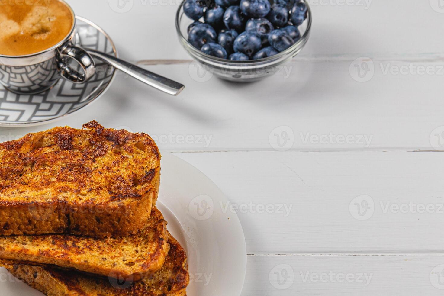 French toast on a white plate with blueberries and coffee for breakfast photo
