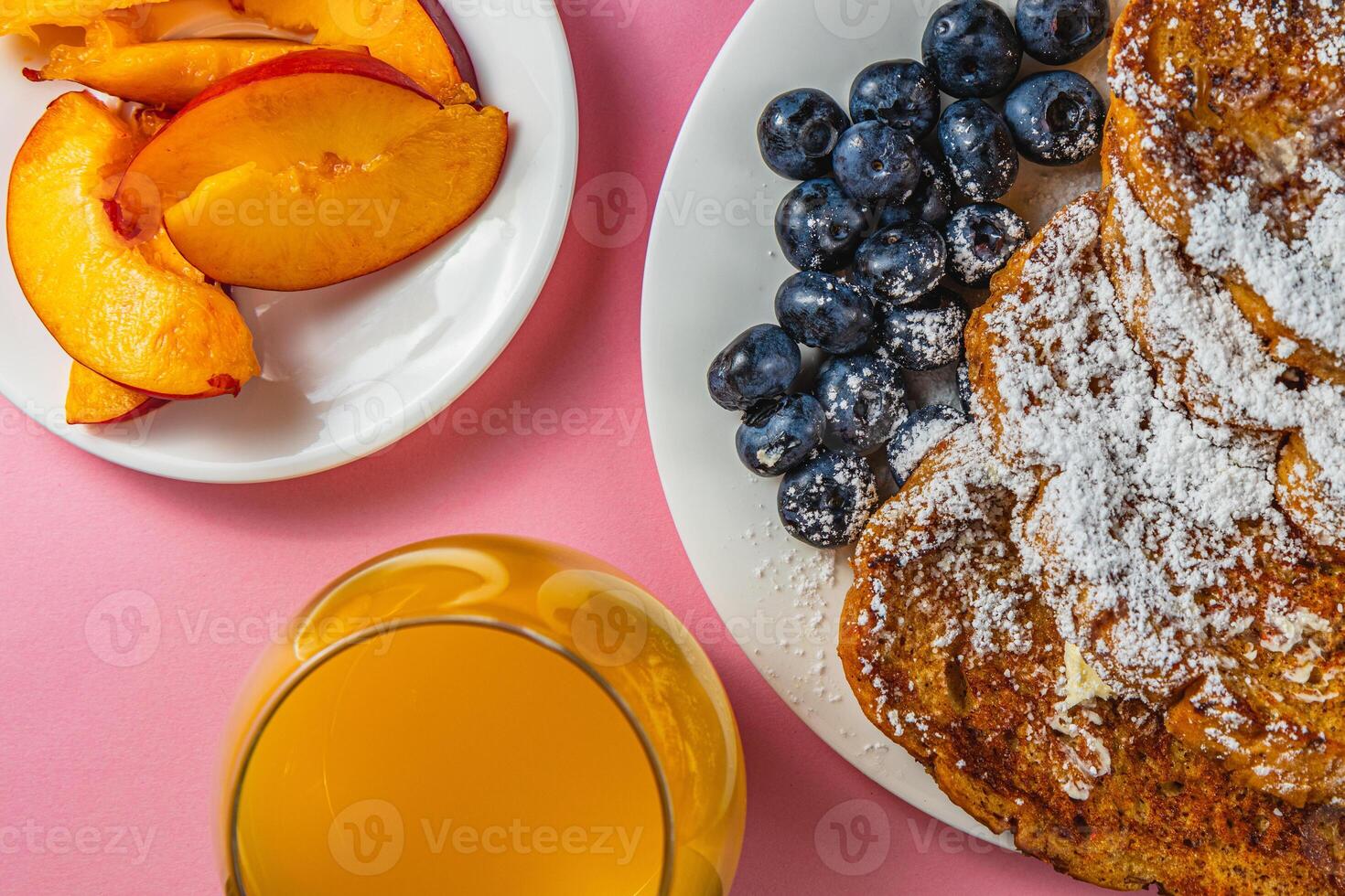 French toast on a plate with blueberries, orange juice, nectarine for breakfast photo