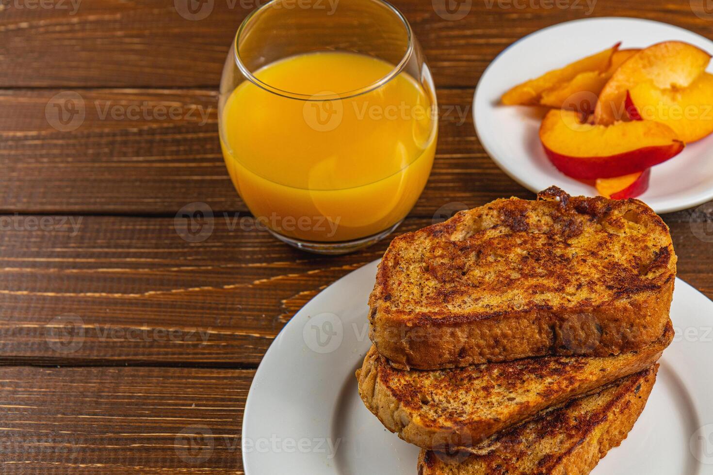 French toast on a plate with blueberries, orange juice, nectarine for breakfast photo