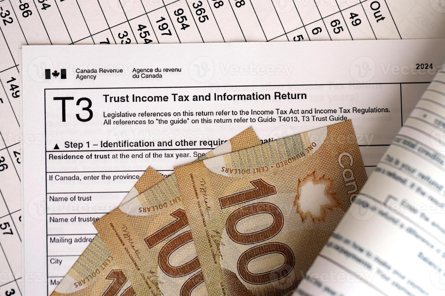 Canadian T3 tax form Trust income tax and information return lies on table with canadian money photo