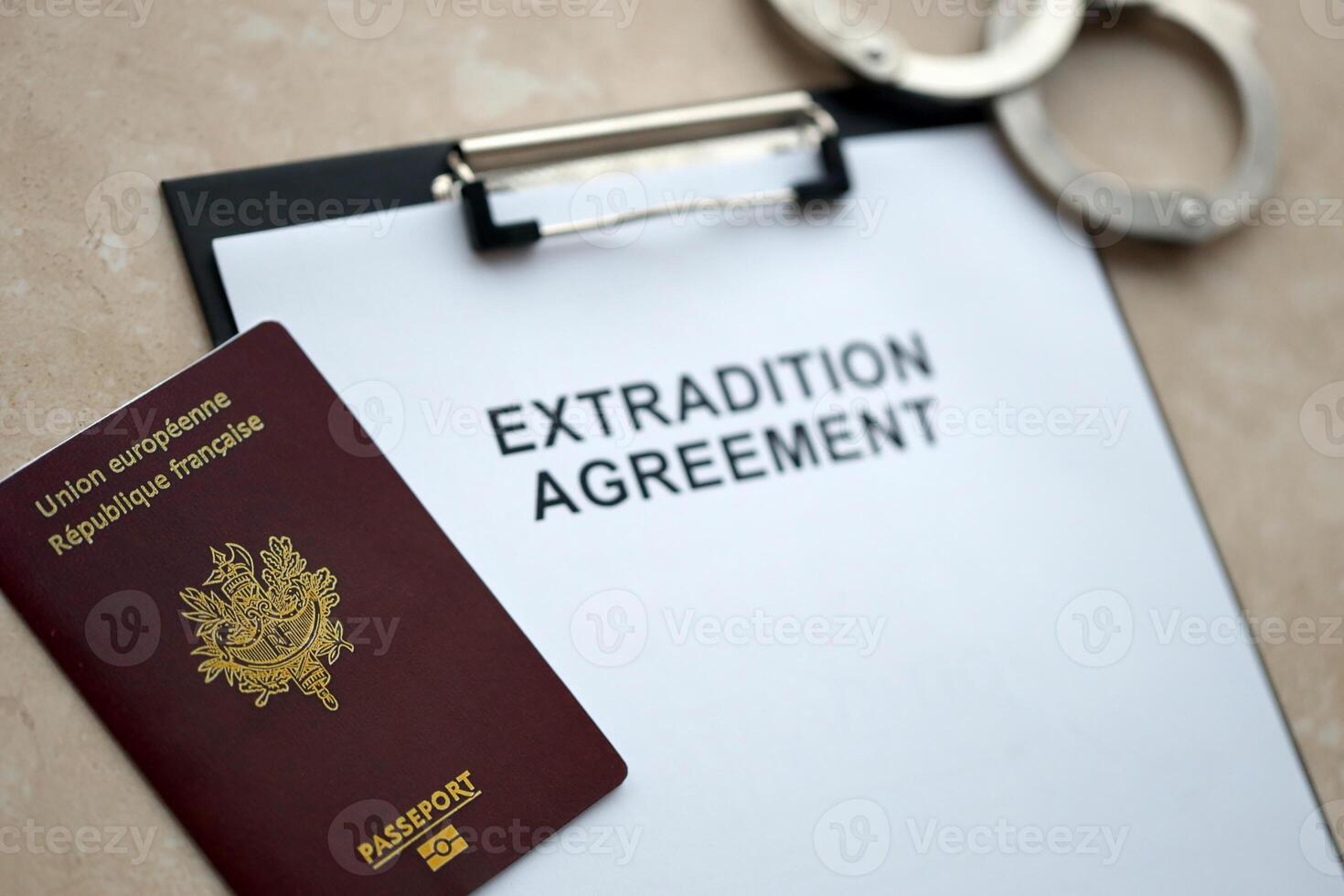 Passport of France and Extradition Agreement with handcuffs on table photo