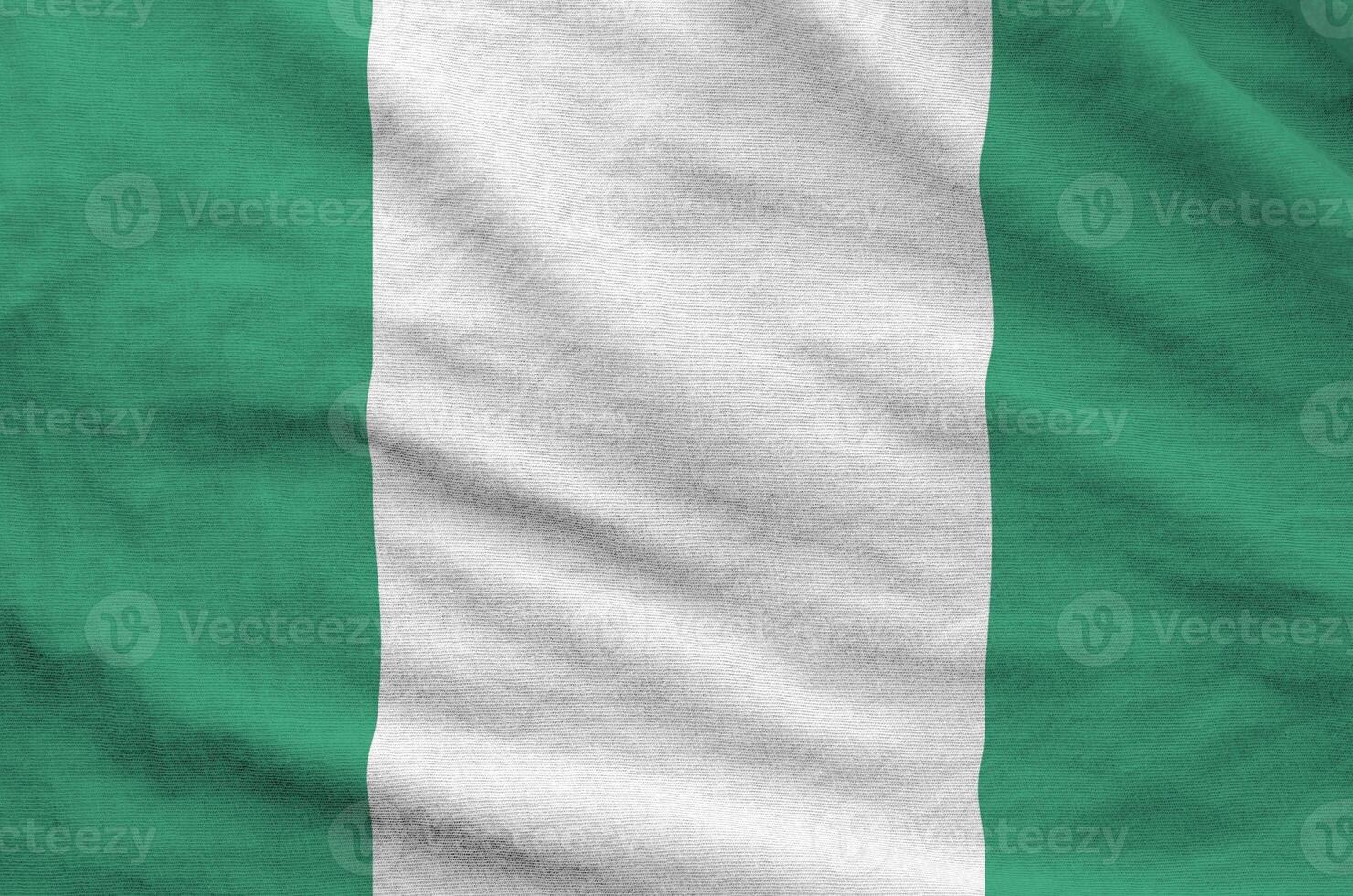 Nigeria flag depicted on folded wavy fabric of old cloth photo