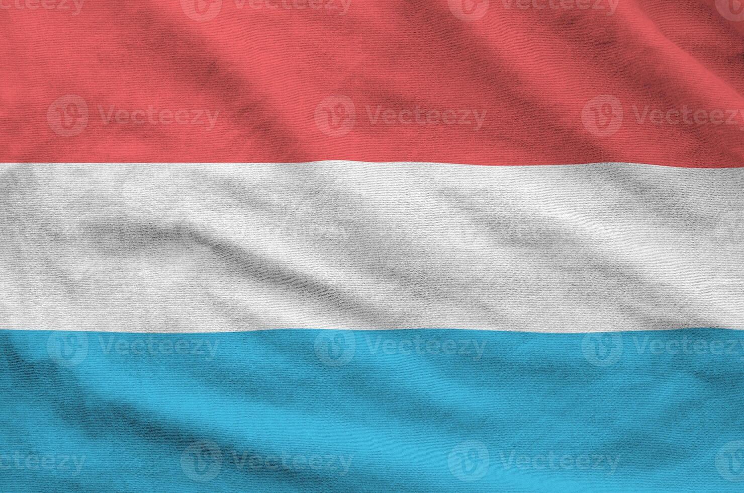 Luxembourg flag depicted on folded wavy fabric of old cloth photo