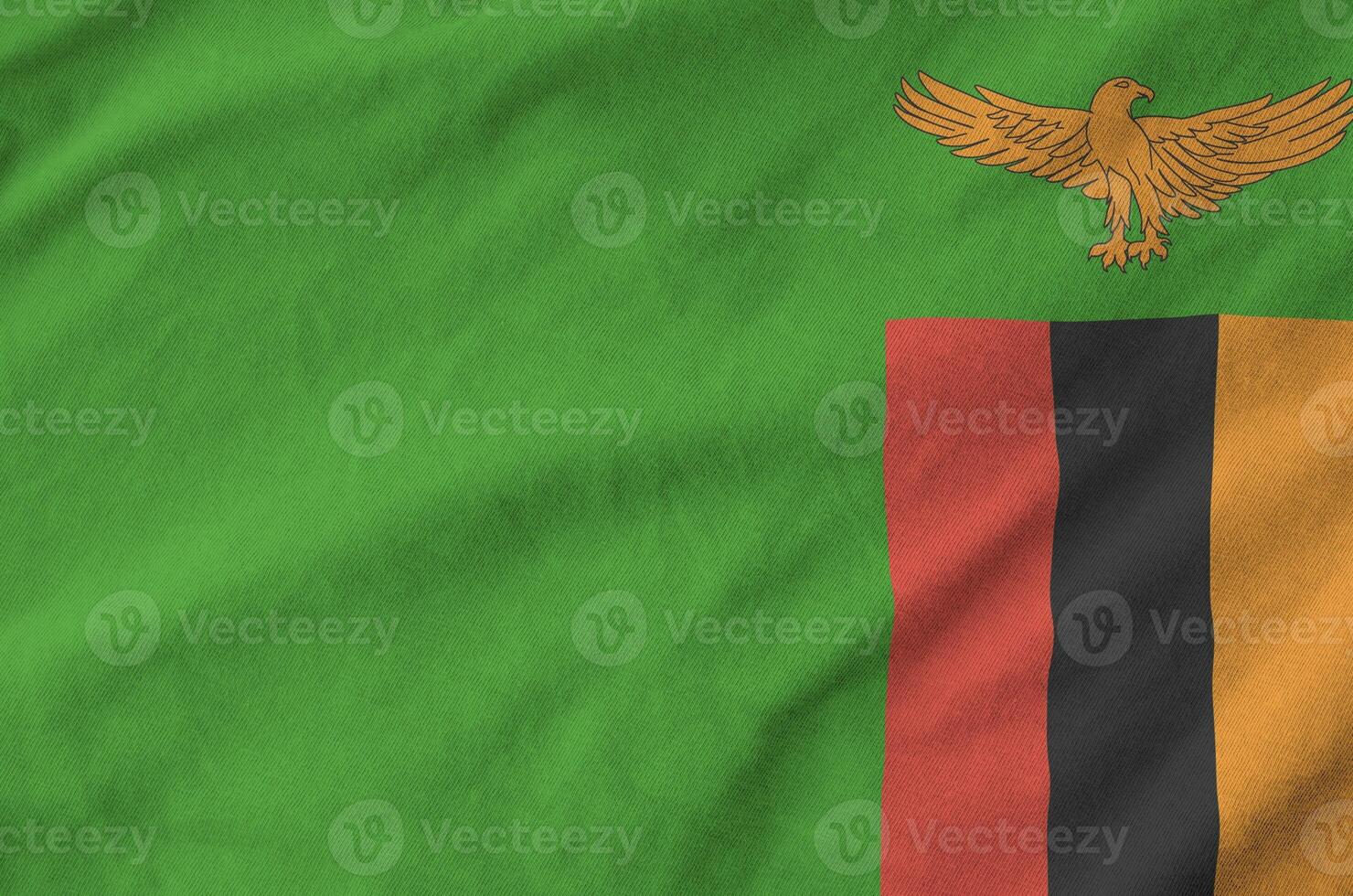 Zambia flag depicted on folded wavy fabric of old cloth photo