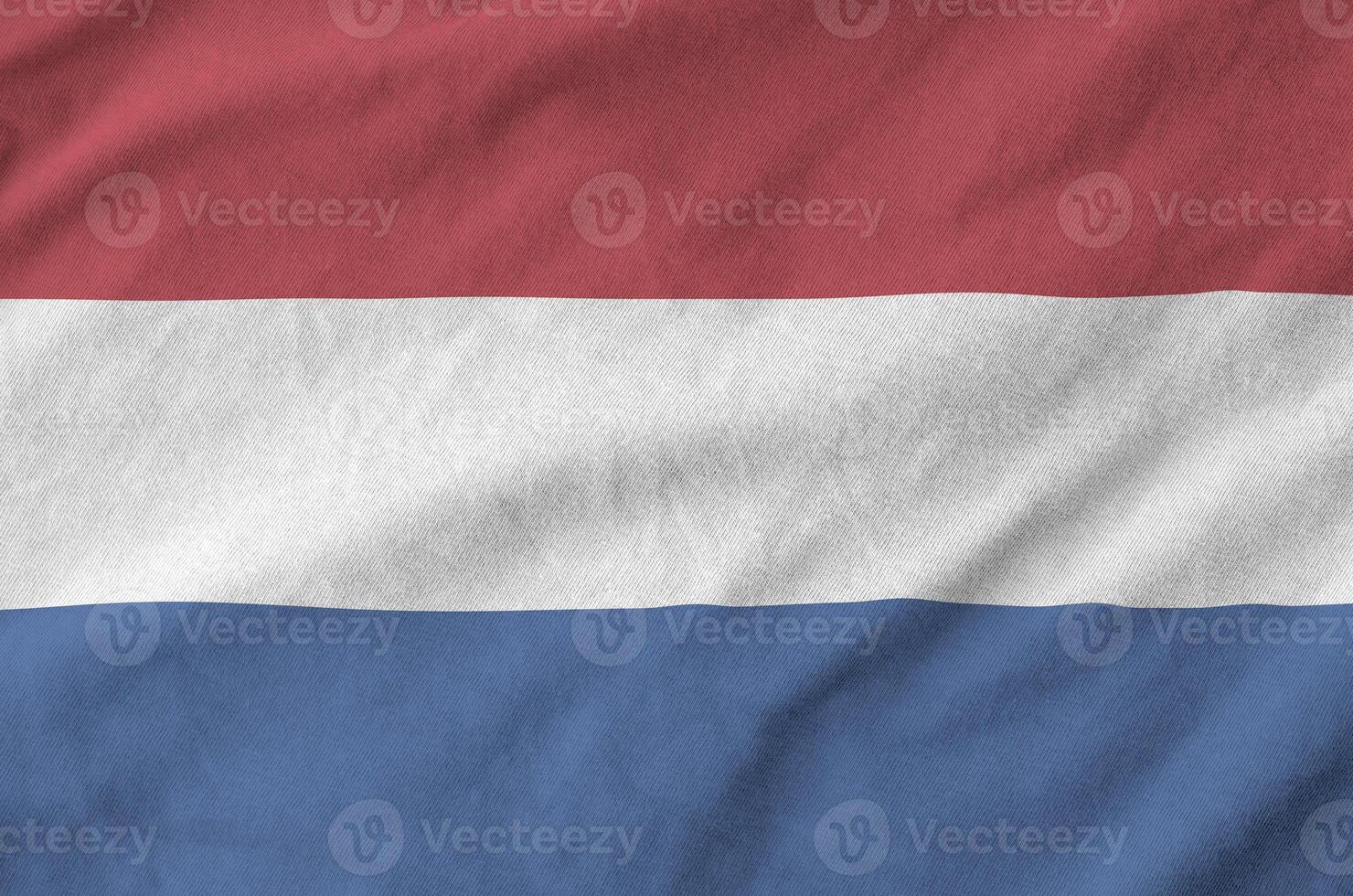 Netherlands flag depicted on folded wavy fabric of old cloth photo