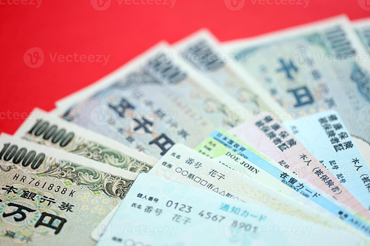 Blue and red Japan Health Insurance cards on table with japanese residence card and my number card photo