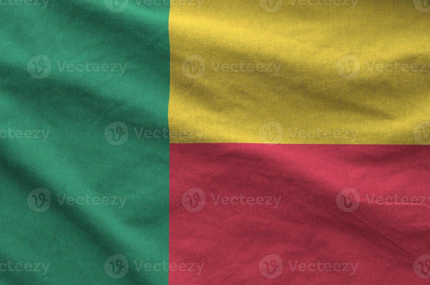 Benin flag depicted on folded wavy fabric of old cloth photo